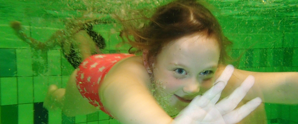 Kind die onder water aan het zwemmen is