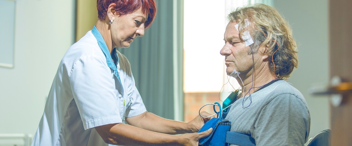 Sleeptechnologist maakt patiënt klaar voor een onderzoek naar slaapapneu